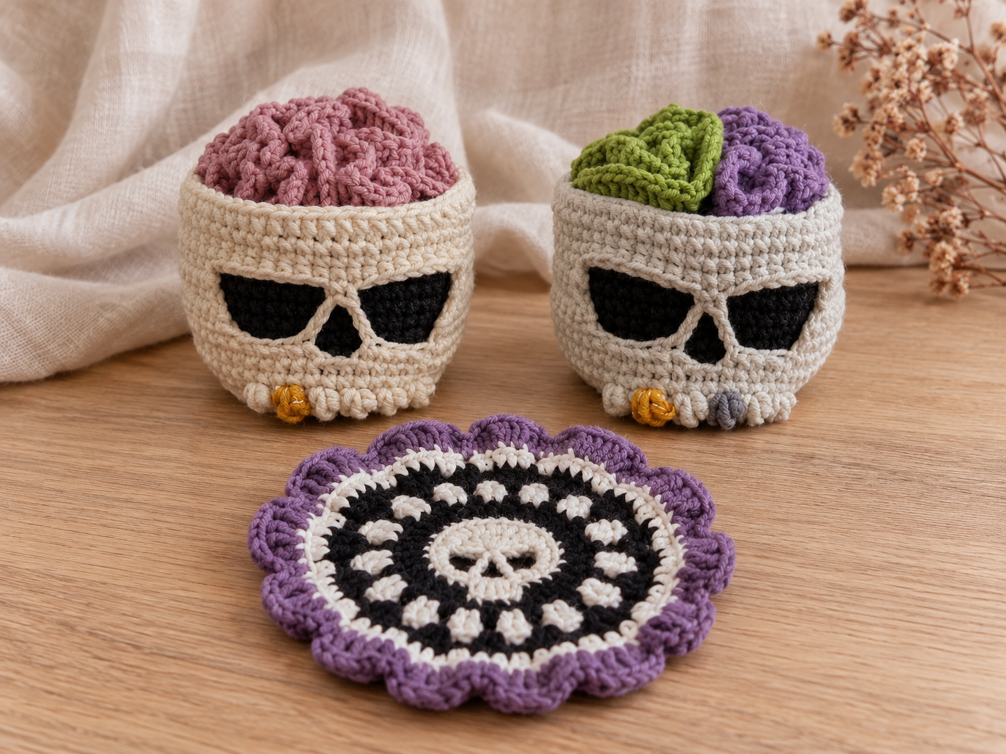 Two Brainy Skull crochet holders with mauve, green and purple color variations