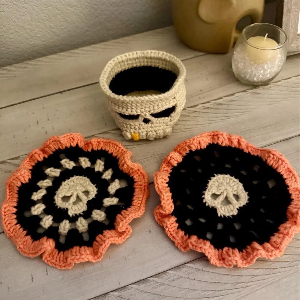 Customer-made black skull crochet coasters with orange ruffled edges