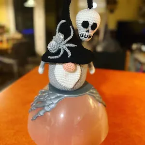 Spooky crochet gnome displayed on Halloween skeleton hand decor